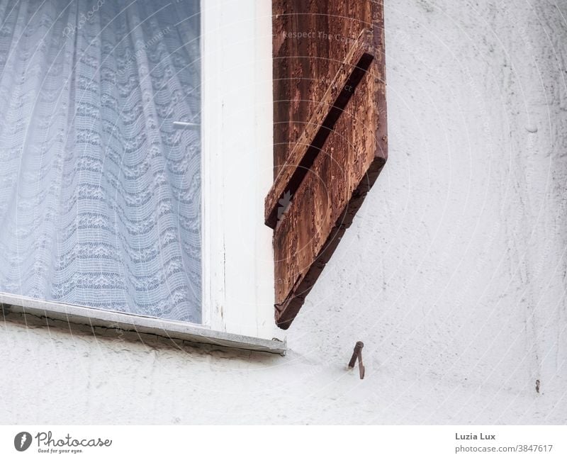 Fensterladen, lose Fensterladenhalter Holz braun dunkelbraun Gardine geheimnisvoll Menschenleer Farbfoto Außenaufnahme Tag Fassade Häusliches Leben Mauer Wand