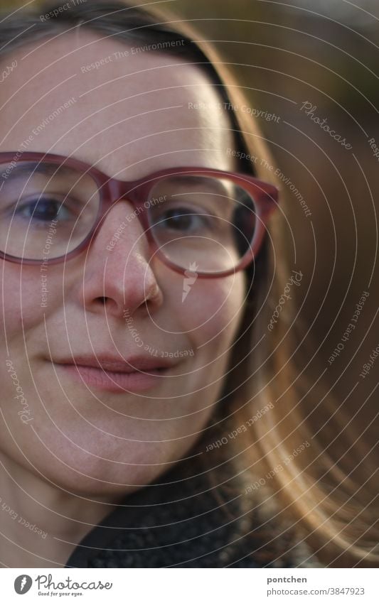 Gesicht einer leicht lächelnden Frau mit brille und braunen haaren. Zufriedenheit natürlich Blick in die Kamera grübchen brünett Brille Nahaufnahme Erwachsene