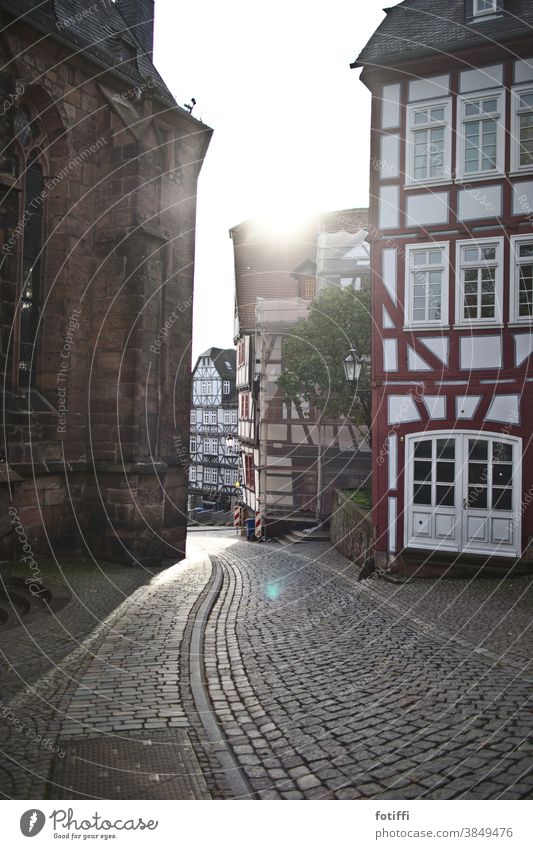 Gasse in Marburg im Gegenlicht Kopfsteinpflaster Straße Fachwerkfassade Fachwerkhaus Altstadt Sonnenlicht Außenaufnahme Menschenleer historisch Tag Architektur