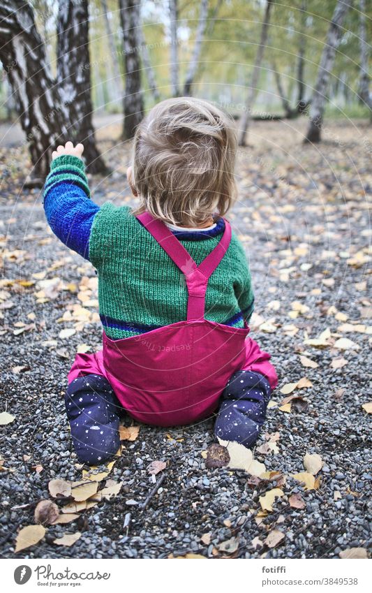 Da geht es lang! Kind Kleinkind Weg Wege & Pfade Wegweiser zeigen hocken Richtung Orientierung links Empfehlung vorschlagen klein niedlich sitzen Regenhose