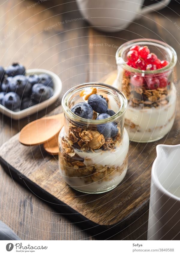 Gemütliches Frühstückskonzept dunkler Holzuntergrund Müsli selbstgemacht Hafer Joghurt Sesam gebacken hölzern Hintergrund Tisch rustikal gemütlich dunkel Kaffee