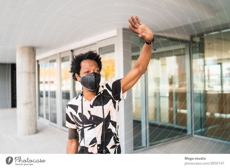 Afrotourist, der auf der Straße ein Taxi ruft. Afro-Look Tourist Mann Reisender Koffer Ausflugsziel Konzept Feiertag Tag Freude genießen Abenteuer Spaziergang