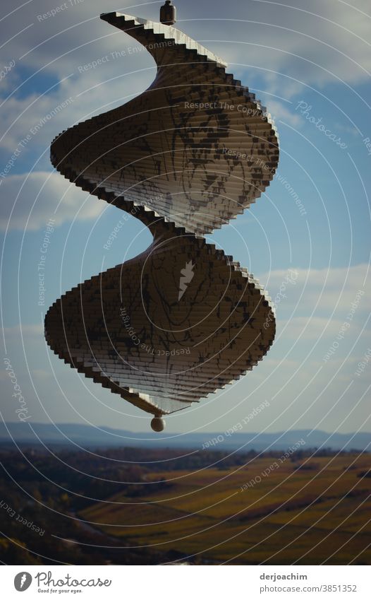 Windspirale hängt an einer Befestigung . Blauer Himmel mit Wolken und der Horizont. Architektur windspirale Moderne Architektur Außenaufnahme Farbfoto modern