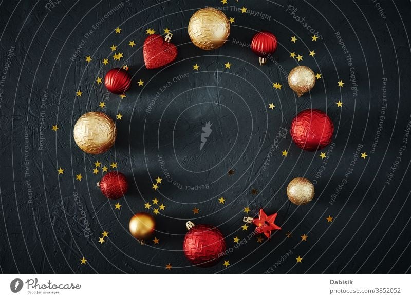 Weihnachtskomposition. Runder Rahmen aus roten und goldenen Weihnachtskugeln und festlichen Bändern auf dunklem Hintergrund, Draufsicht Weihnachten