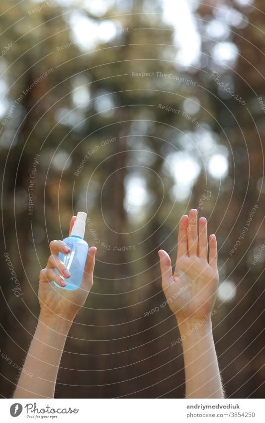 Frauenhände, die Alkoholspray oder Anti-Bakterien-Spray im Freien halten, um die Verbreitung von Keimen, Bakterien und Viren zu verhindern, Quarantänezeit, Konzentration auf Hände aus nächster Nähe. Coronavirus.