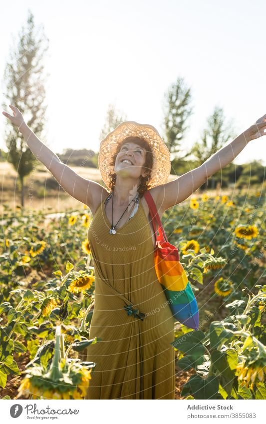 Frau entspannt im Sonnenblumenfeld Feld genießen Natur Blütezeit Blume Saison sonnig sorgenfrei Regenbogen Tasche stehen Windstille Wetter ruhig friedlich