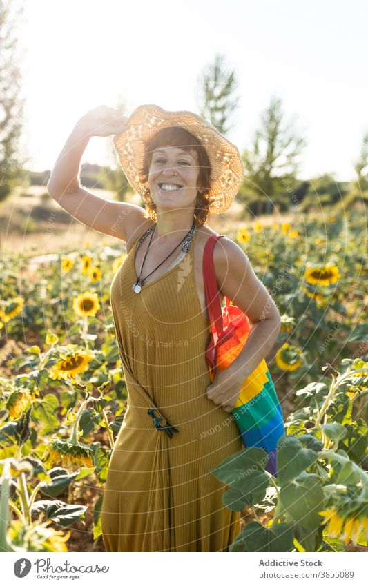 Ruhige Frau entspannt in Sonnenblumenfeld Feld genießen Natur Blütezeit Blume Saison sonnig sorgenfrei Regenbogen Tasche stehen Windstille Wetter ruhig