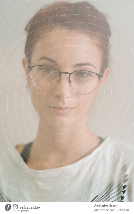 Kluge Frau schaut in die Kamera Vorschein Grinsen klug jung Porträt Brille lässig selbstbewusst Individualität clever modern Model Accessoire intelligent