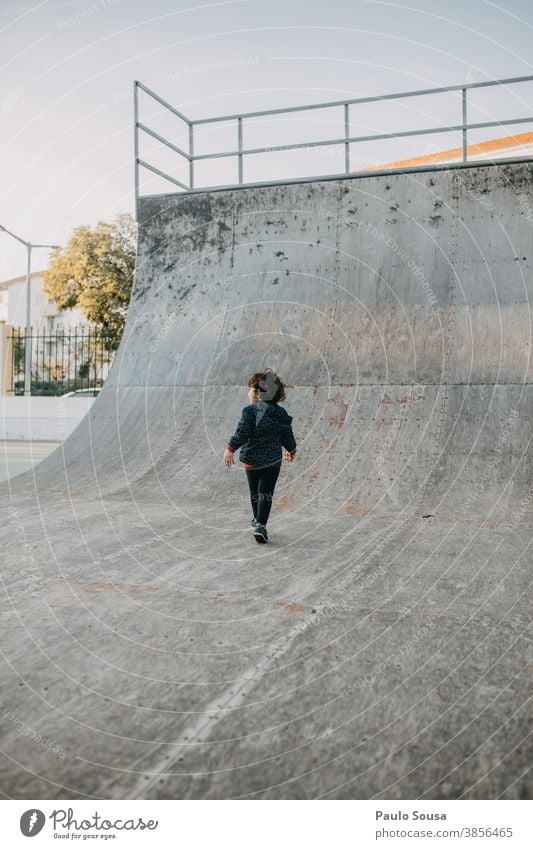 Rückansicht eines im Skatepark spielenden Kindes Skateboarding Skateplatz Halfpipe Kindheit Kinderspiel Park Herbst authentisch copyspace Textfreiraum