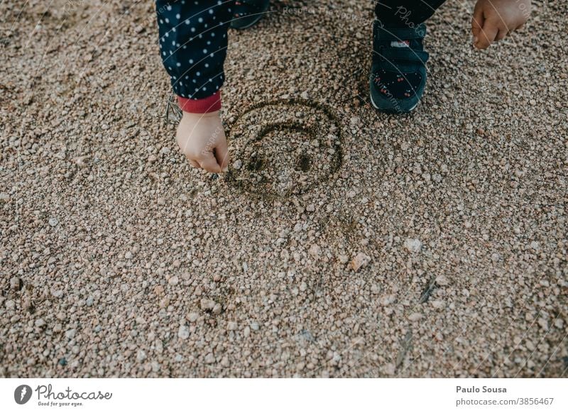 Kind malt ein Lächeln auf Sand Smiley Kindheit Kinderspiel Freude Außenaufnahme Kindheitserinnerung Spielen Farbfoto Kleinkind Fröhlichkeit mehrfarbig 1-3 Jahre