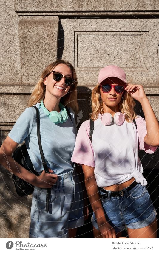 Trendige junge Frauen mit Standing in der Stadt Freund urban blond trendy Zusammensein Glück Teenager heiter Mädchen Sonnenbrille Freundin Kopfhörer cool