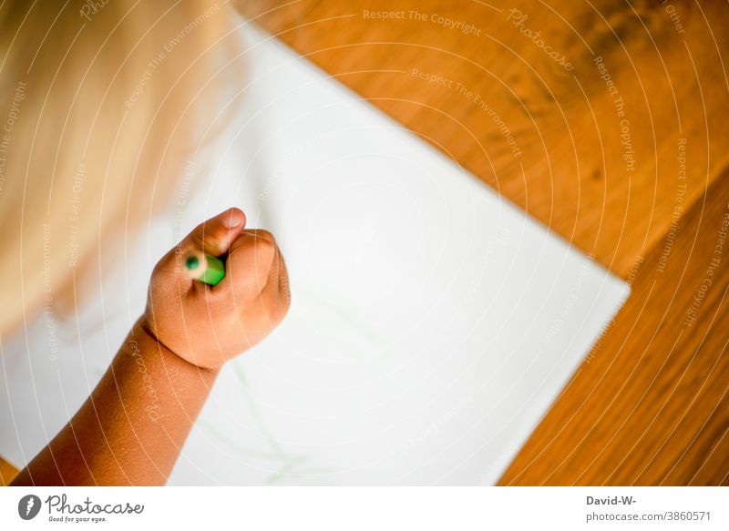 Kind malt mit einem Buntstift auf einem Blatt Papier malen Kreativität Beschäftigung Bildung Kindererziehung Kindergarten