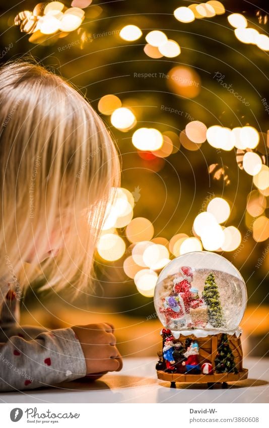 kleines Mädchen schaut an weihnachten in eine Schneekugel Weihnachten & Advent wünschen Wunsch Glaube Vorfreude Weihnachtsmann leuchten Weihnachtsbaum Freude