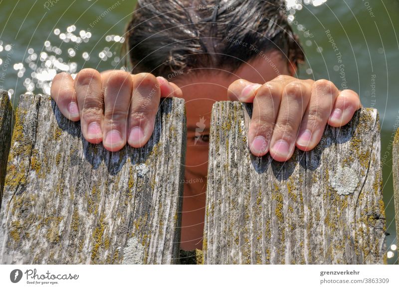 Kind im Wasser hält sich am Steg fest Schwimmen & Baden Freizeit & Hobby Sommerurlaub Strand Kindheit Mensch 8-13 Jahre Abenteuer Freude Badestelle Badesee See