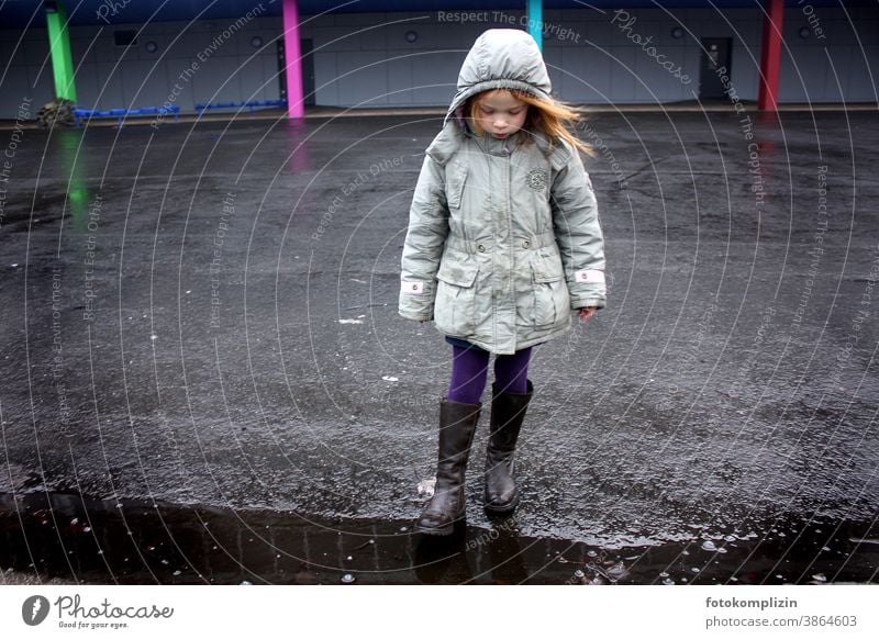 Kind steht alleine auf einem Schulhof Schulkind Mädchen Schule konzentriert leer Einsamkeit Kindheit verträumt wartend traurig einsam ernst zögern Kinder