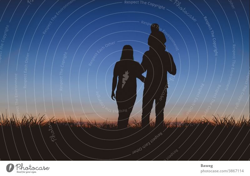 Familie beim Spaziergang zum Sonnenuntergang Silhouette Silhouetten Auszeit Baum Sonnenaufgang Frau Mann Kind Paar Beziehung Draussen Ehe Entspannung Freizeit