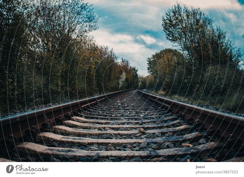 Bahngleise in der Landschaft - am Horizont blauer Himmel und weiße Wolken Gleise Schiene Eisenbahn Zug Transport Verkehr Schienenfahrzeug parallel Weg Gleisbett