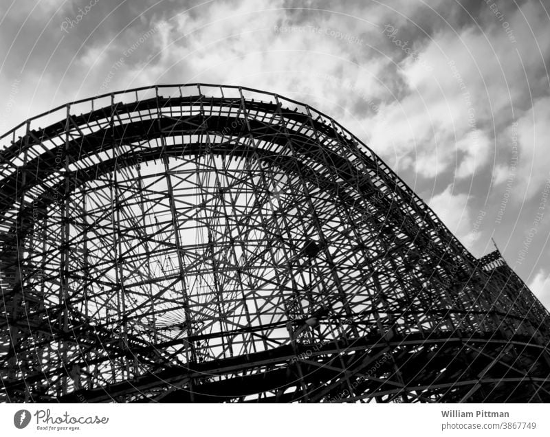 Achterbahn in Schwarz-Weiß Vergnügungspark Außenaufnahme Fahrgeschäfte Menschenleer Schwarzweißfoto Angst dunkel dramatisch geheimnisvoll Bauwerk