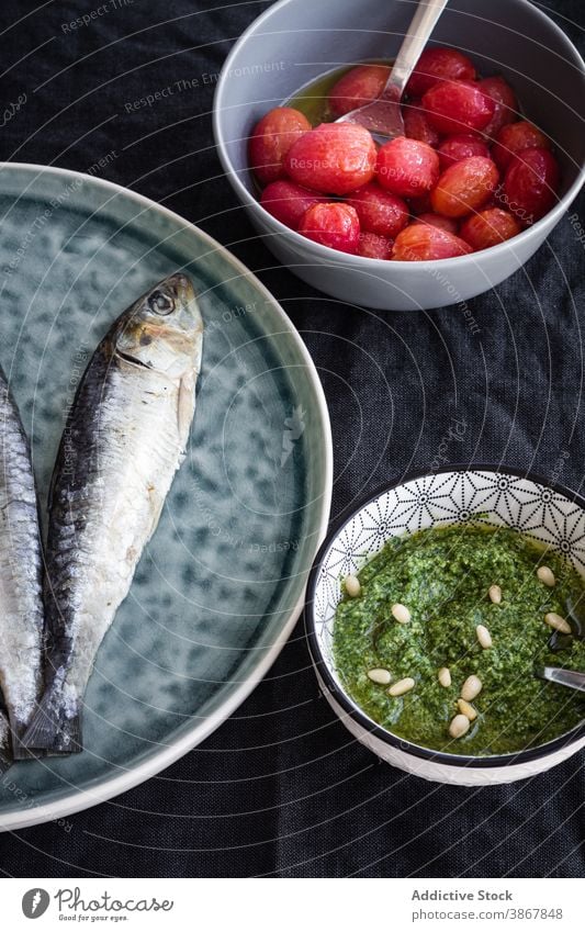 Fisch mit Sauce Pesto und marinierten Tomaten Saucen Lebensmittel Hering Bestandteil Mahlzeit Speise Küche Teller Schalen & Schüsseln salzig mediterran lecker