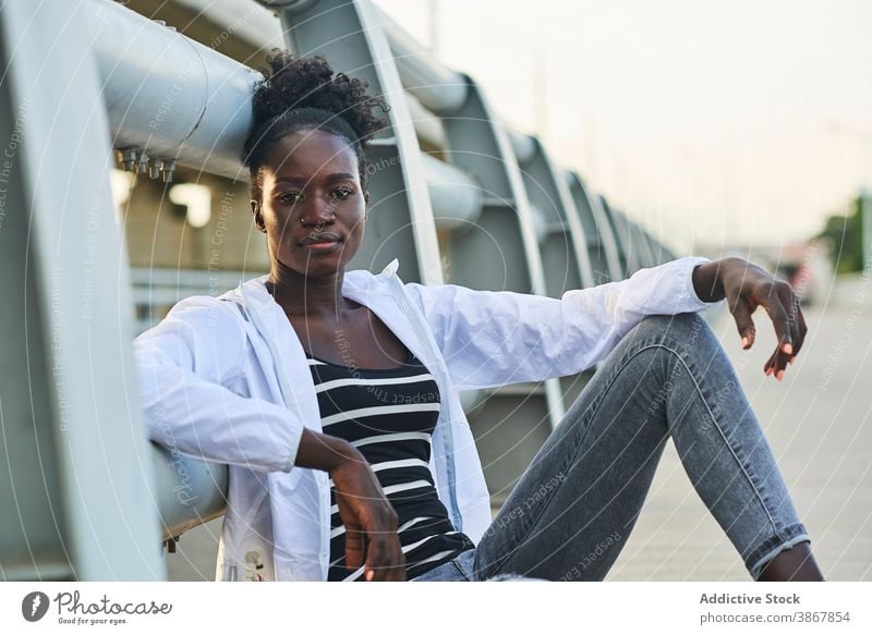 Lächelnde afroamerikanische Frau, die sich auf der Straße ausruht heiter Glück urban jung genießen positiv ruhen Inhalt Afro-Look schwarz Schüler Afroamerikaner