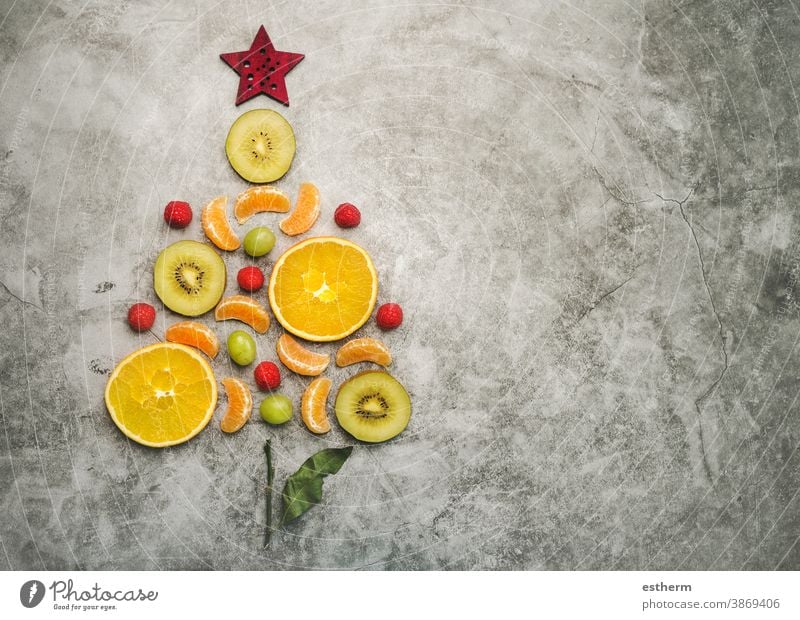 Hintergrund des Weihnachtskonzepts. Obststücke in Form eines Weihnachtsbaums Weihnachten Früchte orange gesunde Ernährung Diät Weihnachtsdessert Kiwi Scheibe