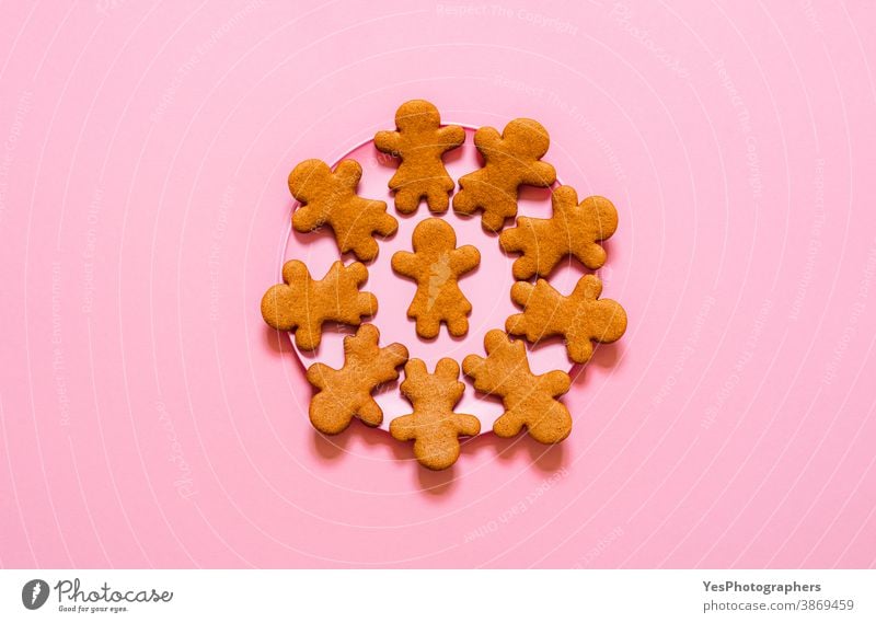 Lebkuchenplätzchen auf einem Teller. Plätzchen in Mädchenform auf rosa Hintergrund, Draufsicht Weihnachtsplätzchen Frohe Weihnachten obere Ansicht gebacken