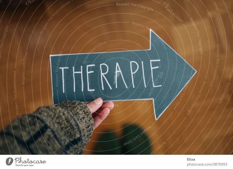 Eine Person hält einen Pfeil mit der Aufschrift Therapie. Konzept Psychotherapie bei psychischen Erkrankungen, wie beispielsweise Depressionen, Angststörungen und Suchtproblemen.