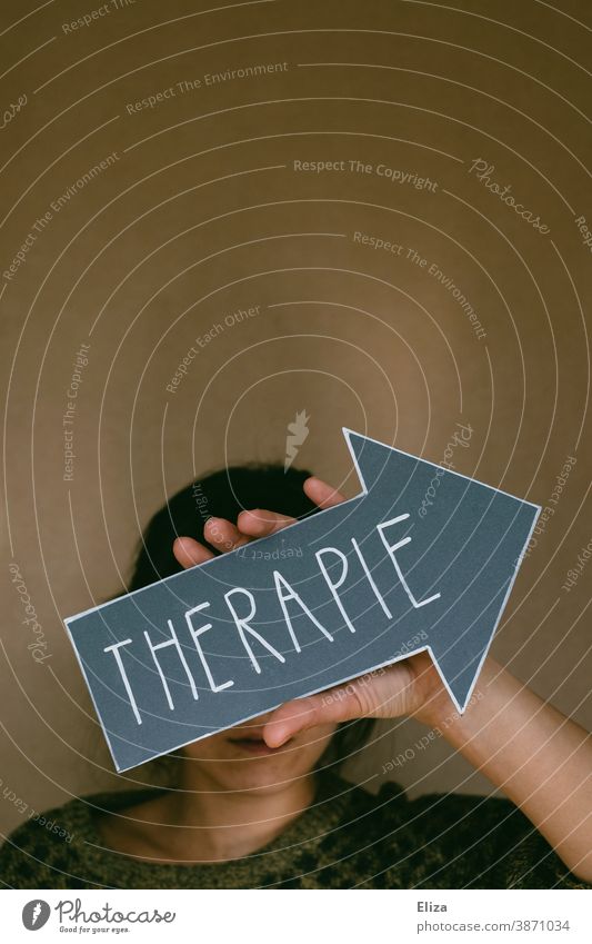 Eine Frau hält einen Pfeil mit der Aufschrift Therapie. Konzept Psychotherapie bei psychischen Erkrankungen, wie beispielsweise Depressionen, Angststörungen und Suchtproblemen.