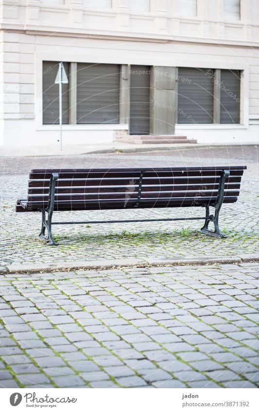 beobachterposition. Bank Textfreiraum unten Tag Sitzgelegenheit Einsamkeit ruhig Pause Gebäude Rollladen Treppe Pflastersteine menschenleer Herbstlaub