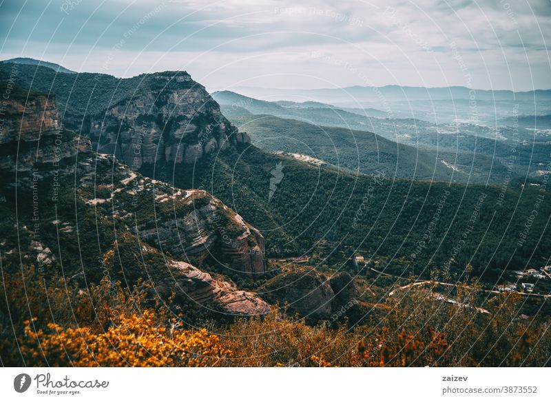 Eine imposante Landschaft mit zerklüfteten Bergen und Feldern, die sich bis zum Horizont erstrecken Cingles de Bertí Riscos de Berti sant miquel del fai Bäume