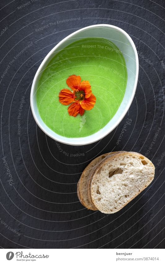 cremige Erbsensuppe auf schwarzem Schiefer Suppe Hülsenfrüchte Gemüse Brei Püree oval lecker Übersicht grün gesund Essen Abendessen Sahne Kochen vegetarisch