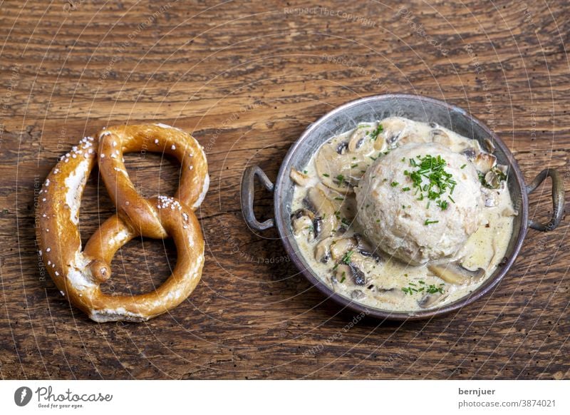 bayerischer Semmelknödel mit Sauce Breze Brezel Pilzsauce Pilzsoße Kupfer Topf Knödel Kloß Aufsicht schwammerlsoße Gericht Bayern traditionell Essen Abendessen