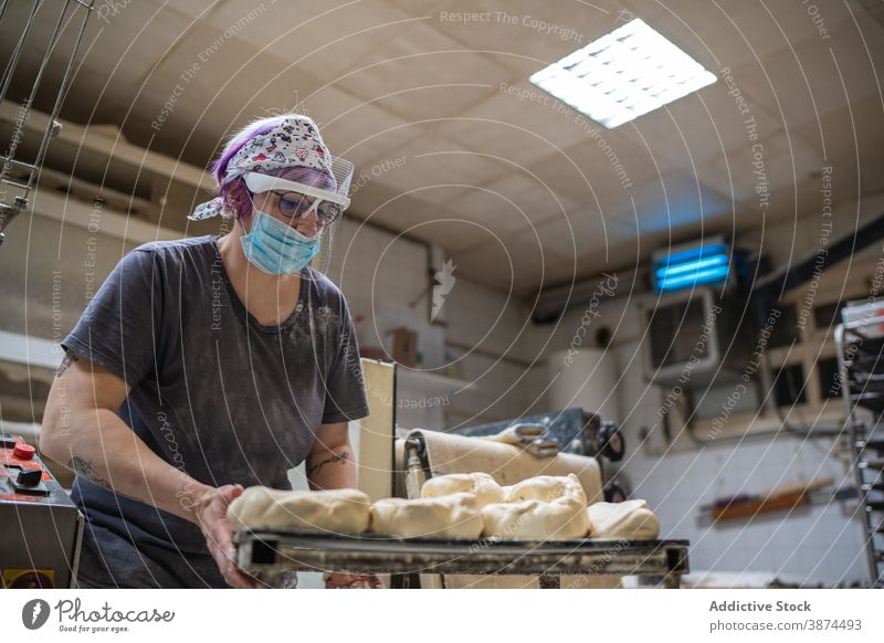 Bäcker bereitet Teig zum Backen vor Teigwaren Bäckerei Brot Frau vorbereiten ungekocht Form rund Mundschutz Schutzschild Tisch Küche Arbeit kulinarisch roh Koch