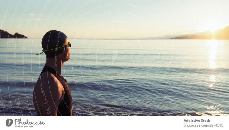 Männlicher Schwimmer mit Schwimmbrille am Meer Mann Schutzbrille MEER Meeresufer professionell Sportler Badeanzug Verschlussdeckel Strand männlich selbstbewusst