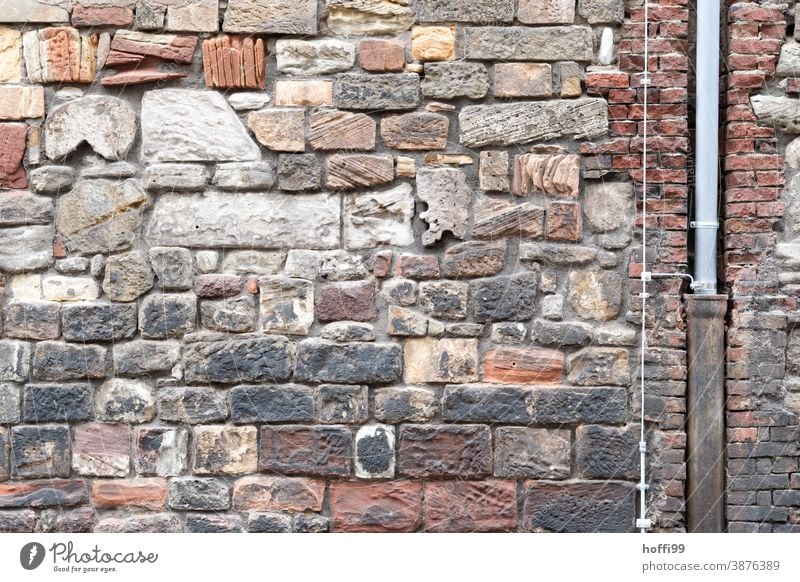 Sandsteinfassade mit Fallrohr und Blitzableiter Sandsteinmauer Abflussrohr Stehender Stein Burgmauer Fassade Altstadt altes Stadthaus Burg oder Schloss Bughof