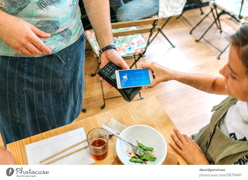 Weiblicher Kunde, der die Restaurantrechnung mit einer virtuellen Handykarte bezahlt bezahlen Kreditkarte Geld sicherer Handel Draufsicht elektronisch Zahlung