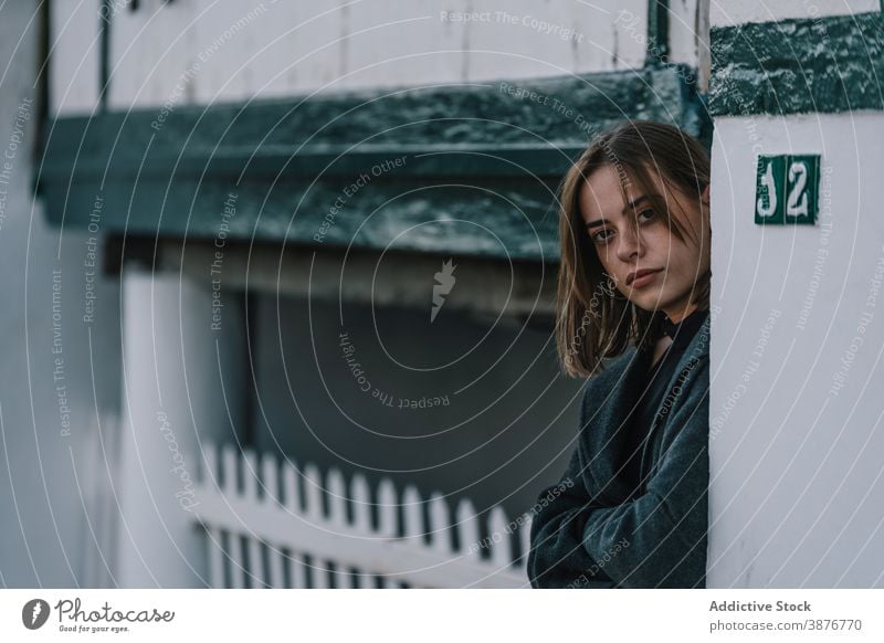 Junge Frau steht in der Nähe von Gebäude in der Stadt Straße emotionslos fettarm alt Melancholie Großstadt stehen Stimmung ernst jung wolkig bedeckt Außenseite