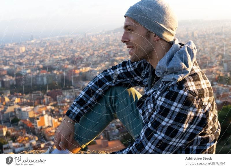 Nachdenklicher Reisender auf einem Hügel sitzend und die Aussicht betrachtend Hipster besinnlich nachdenklich Mann Zeitgenosse Denken männlich reisen Lifestyle