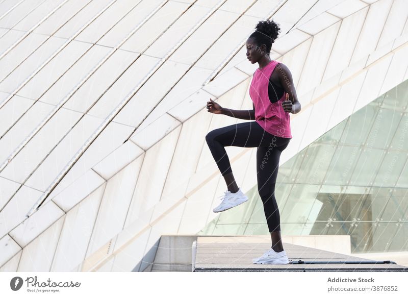 Ethnische Sportlerin beim Aufwärmen der Beine während des Trainings Großstadt Athlet aktiv Dehnung passen Frau ethnisch schwarz Afroamerikaner schlank