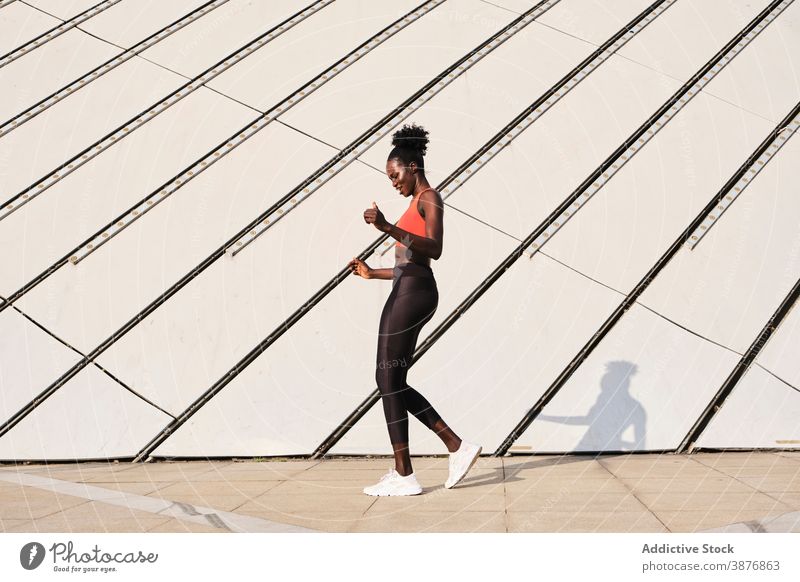 Schwarze Sportlerin auf der Straße an einem sonnigen Tag Athlet Großstadt Frau Lächeln schlank passen heiter Tanzen ethnisch schwarz Afroamerikaner