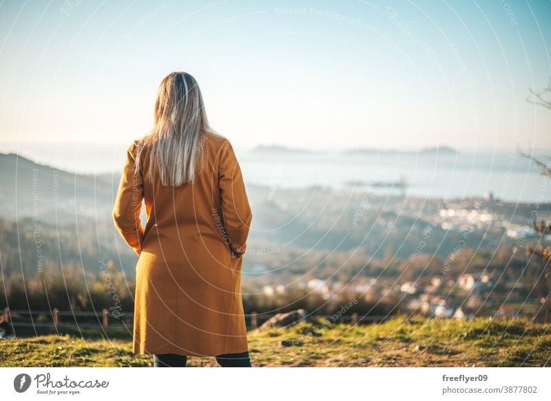 Frau im gelben Mantel beim Betrachten der Landschaft Winter Herbst betrachtend Vigo Galicia Natur im Freien Freiheit Sonnenuntergang Kontemplation Himmel Kühle