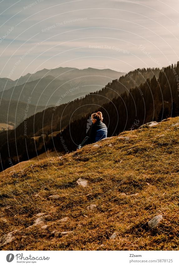 Junge Frau sitzt auf dem Gipfel des Spitzing in den bayerischen Alpen schliersee spitzing wandern herbstfarben junge frau sportlich outtdoor rucksack ausflug