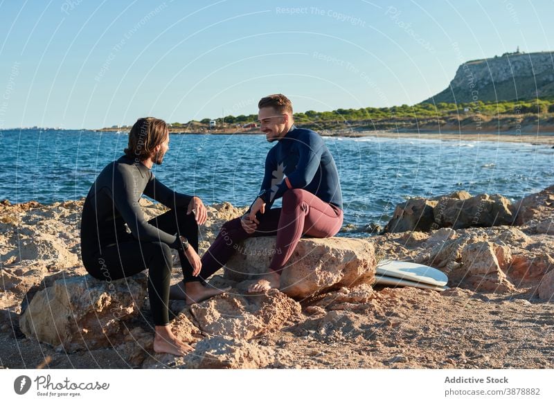 Männer mit Surfbrettern am felsigen Ufer Surfer MEER Zusammensein Freund Wasser Lachen Freundschaft Neoprenanzug Meer Glück Natur Freiheit Sommer