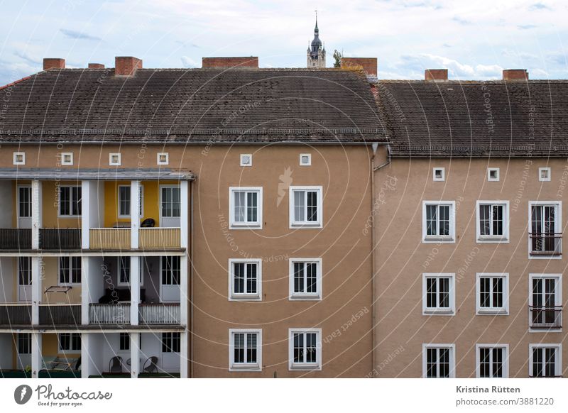 mehrfamilienhäuser mit und ohne balkone haus wohnhaus gebäude architektur fassade loggia loggien kirchturmspitze mehrfamilienhaus wohnblock wohnungen mietshaus