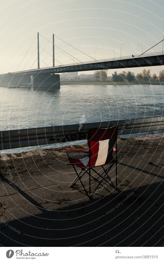 bescheidene aussicht Fluss Stuhl Campingstuhl Aussicht Klappstuhl Brücke Düsseldorf Wasser Leitplanke Rhein Fernweh Sehnsucht Schönes Wetter Wolkenloser Himmel