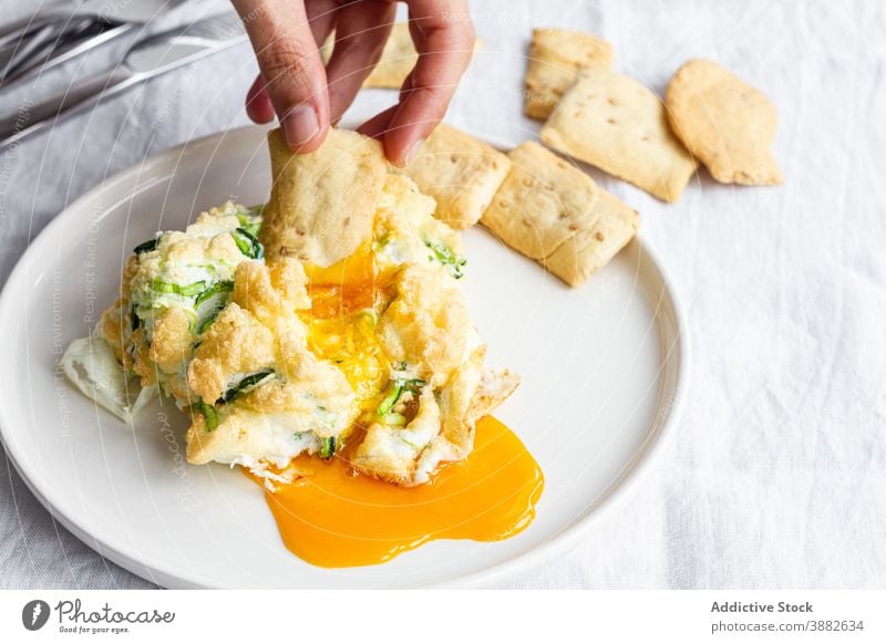 Traditionelle Wolkeneier mit Gemüse zum Frühstück Ei Cloud Eigelb Dip essen Cracker Lebensmittel Gesundheit selbstgemacht lecker geschmackvoll Mahlzeit Hand