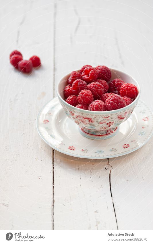 Reife Himbeeren in Schale auf Holztisch frisch Schalen & Schüsseln Beeren reif Frühstück aromatisch Lebensmittel natürlich Gesundheit Sommer weiß hölzern