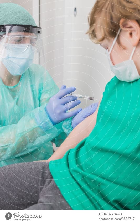 Arzt gibt Injektion für Kind in Maske im Krankenhaus Impfstoff Coronavirus Einspritzung Spritze verhindern Bund 19 steril Gesundheitswesen medizinisch COVID