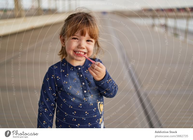 Adorable Mädchen spielen mit Kaugummi Kauen Zahnfleisch Kind Kindheit unterhalten neugierig Spaß wenig niedlich Freude hölzern Spazierweg rosa genießen