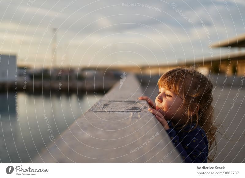 Kleines Mädchen steht auf der Brücke bei Sonnenuntergang Kind neugierig Reling wenig beobachten urban Sommer Abend Lifestyle Kindheit Straße Frau niedlich